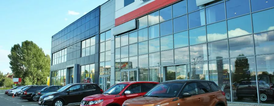 Car dealership A car dealership with cars in front of it.