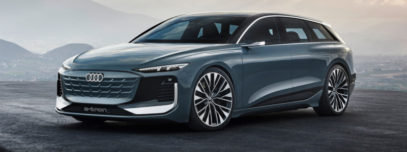 A sleek blue Audi A6 eTron is displayed with a dramatic cloudy sky and distant hills in the background, highlighting the vehicle's modern design and aerodynamic lines.