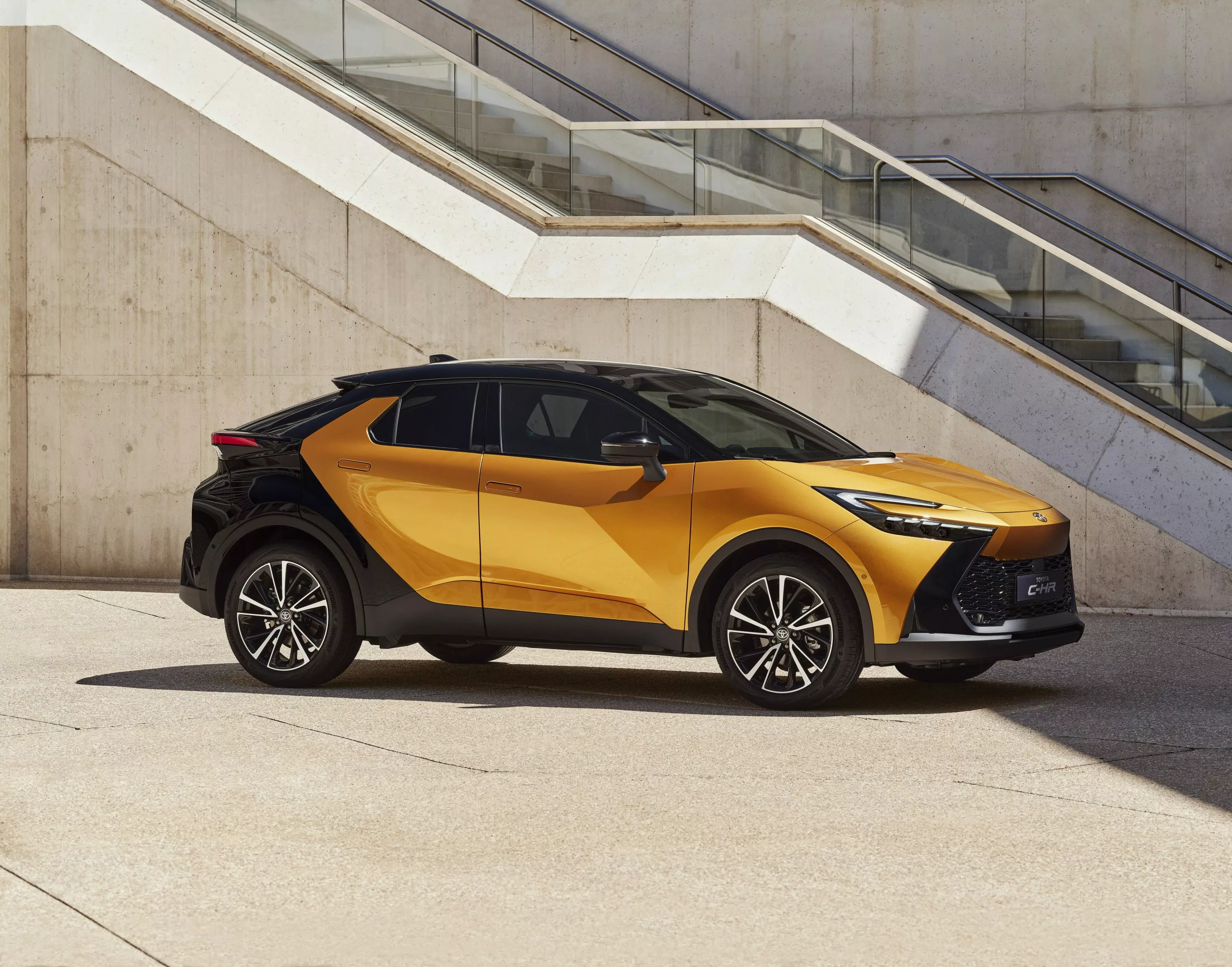 A black and gold Toyota CHR parked against a wall.