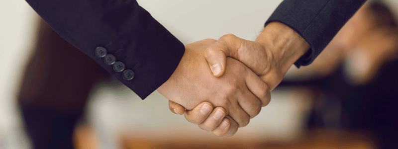 Handshake A close up of a handshake, with both people in blazers, indicating a business agreement.
