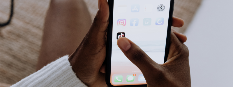 TikTok Phone App A person clicking on the logo for the TikTok app on their smartphone.
