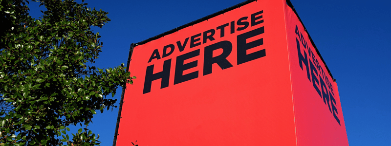 Advertise Here Sign An upward shot of a building with a large red sign over, reading 'ADVERTISE HERE'.