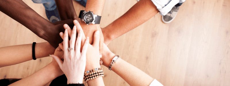 All Hands In An overhead view of multiple hands all together in a circle, symbolising togetherness.