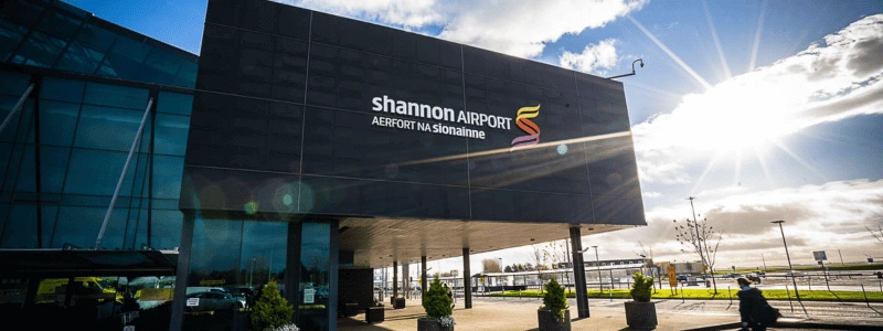 The outside of the entrance to Shannon airport, with sun shining on the entrance.