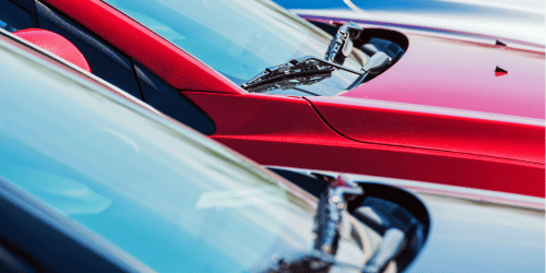 Two cars in focus, both parked next to each other, showing the windscreen and some of the bonnet.