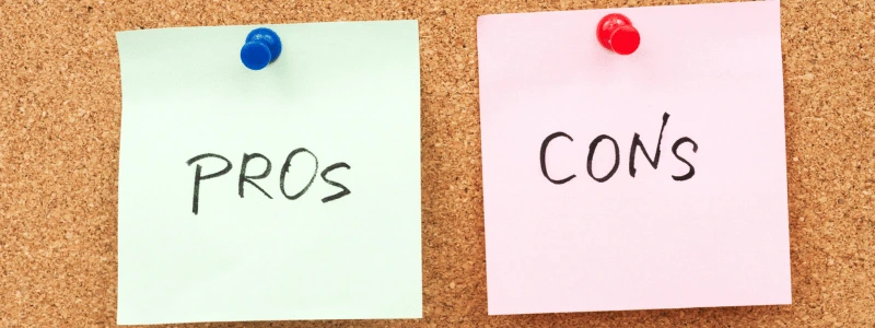Pros And Cons Pinboard Two post it notes, one with 'PROS' written on and one with 'CONS' written on, nailed to a pinboard.