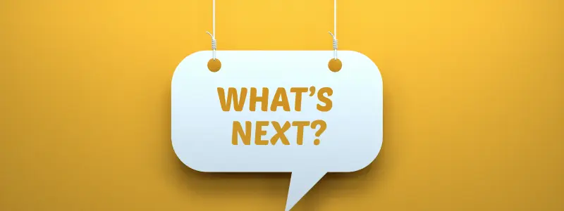 What's Next Sign A sign hanging down reading 'WHAT'S NEXT?' against a yellow background.