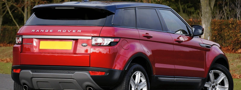 A view of a red Range Rover Evoque from behind.