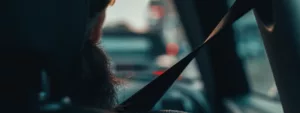 A behind view of a driver, with the seat belt in view, symbolising car safety.