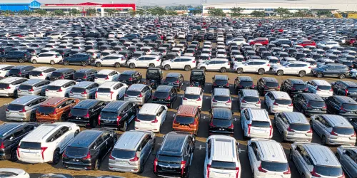 An overhead shot of a car lot, with hundreds of cars parked up.