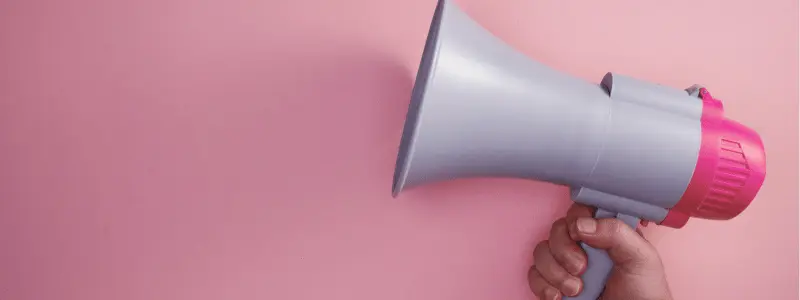 Foghorn A person holding a foghorn in front of a pink background.