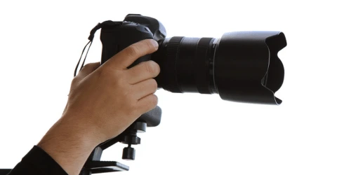 A hand holding a professional camera.