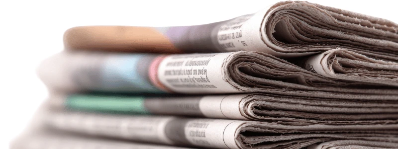 A stack of newspapers all folded in half.