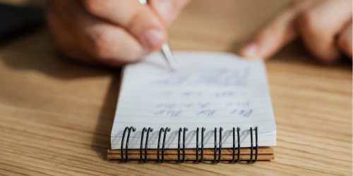 A person writing in a notebook.