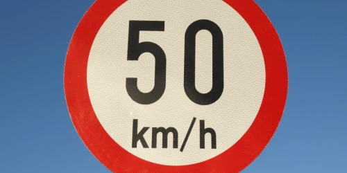A close up of a 50 km/h sign.