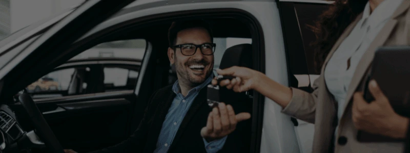 A car key handover in a dealership.