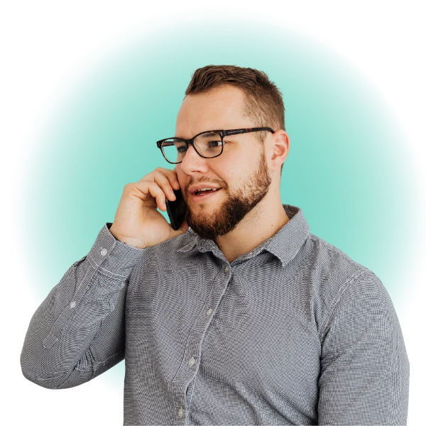 A person on the phone looking to one side, with a green glow behind them.