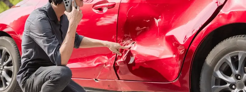 A person inspecting the damage on their car.