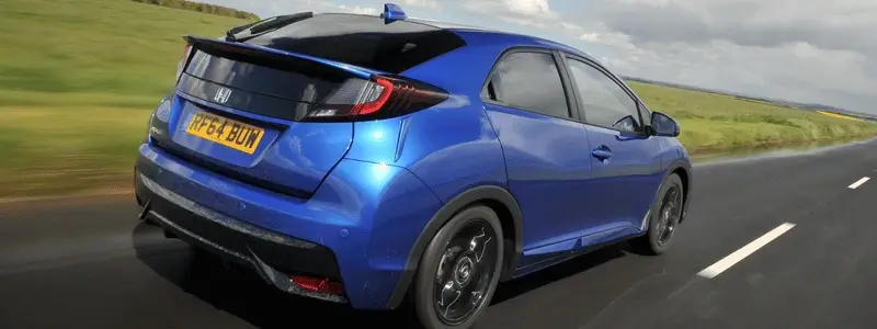 A blue Honda Civic driving on a rural road.