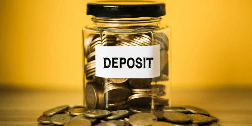 A deposit coin box against a yellow background.
