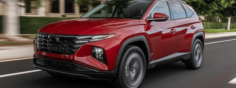 A red Hyundai Tucson on a road.